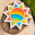 Rainbow sun wall decoration with multicolor triangular rays on white backing