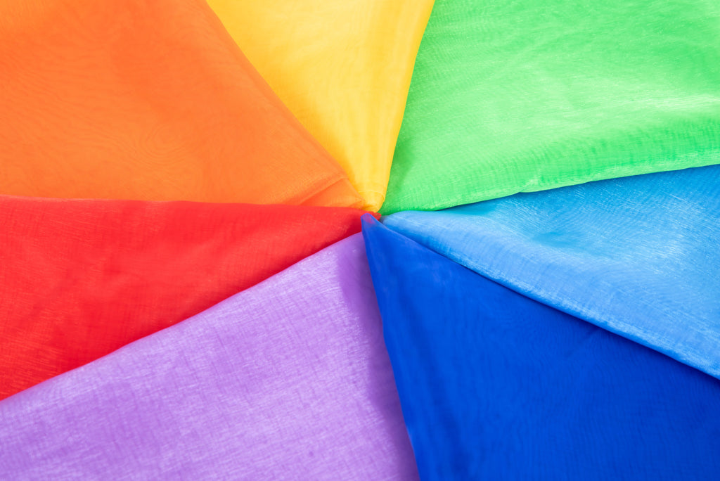 Close-up of folded organza fabric, multicolor panels in red, orange, yellow, green, blue and purple