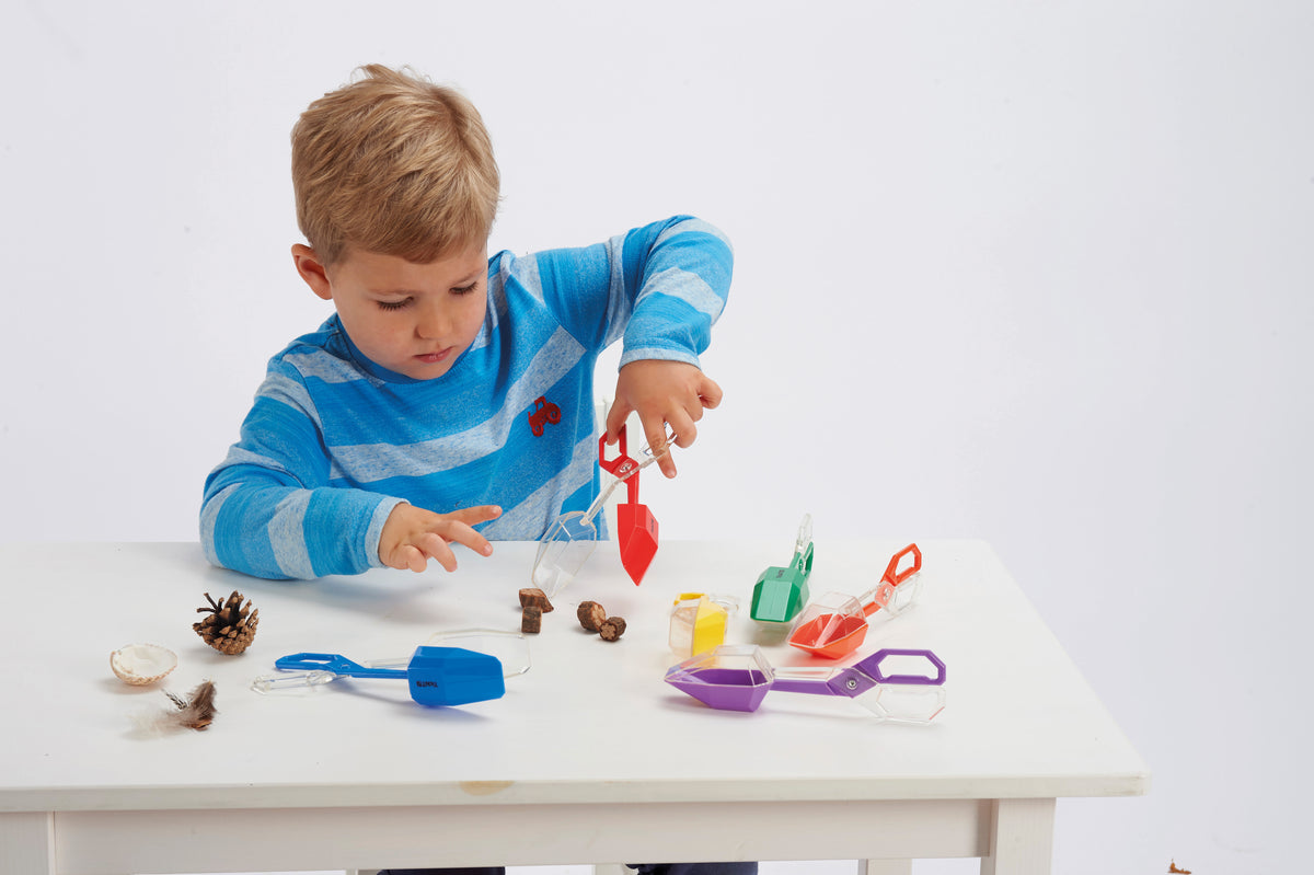 Child holds colorful plastic tongs with scoop tips, multi-color set