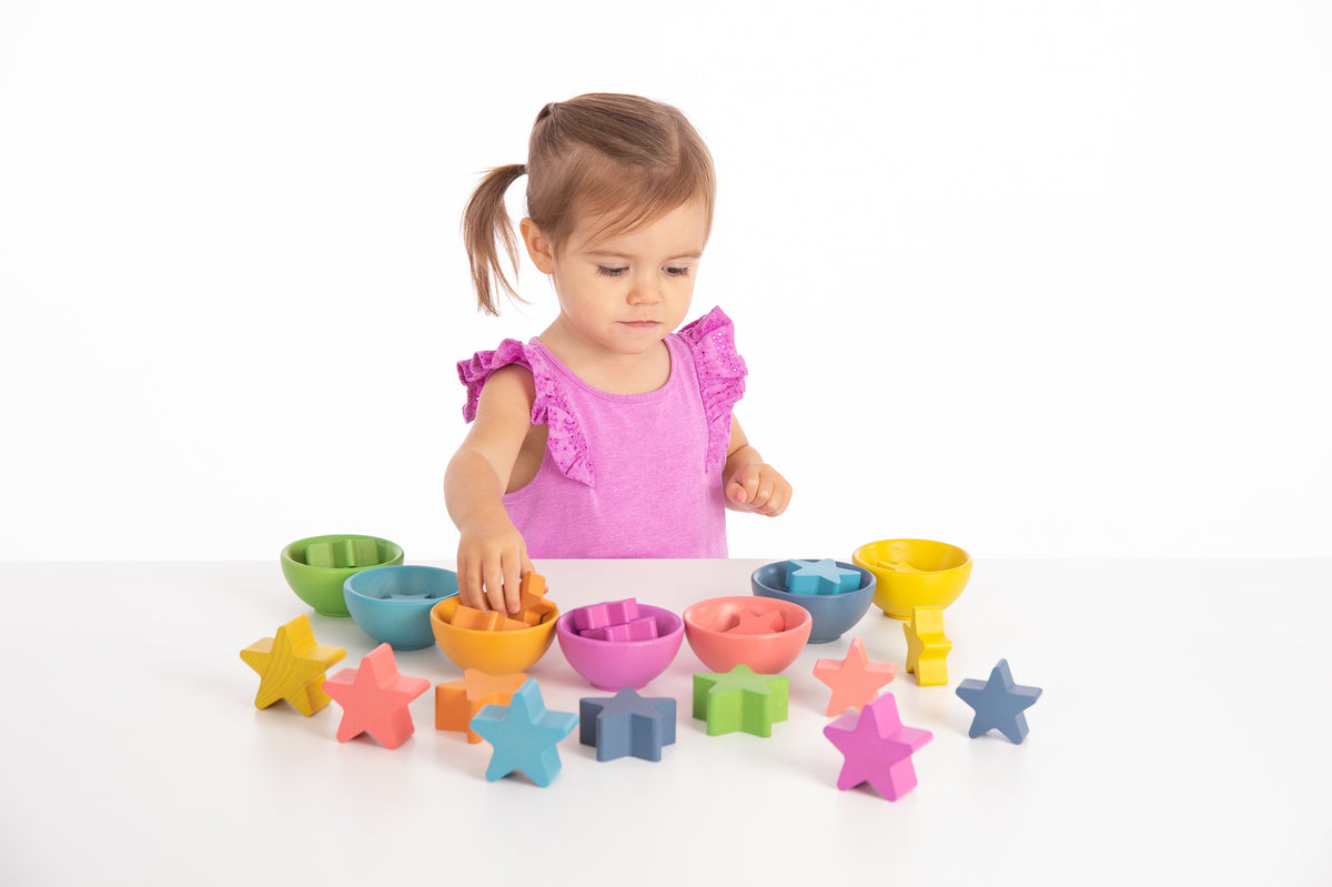 Colorful kid bowls and star toys arranged on a table