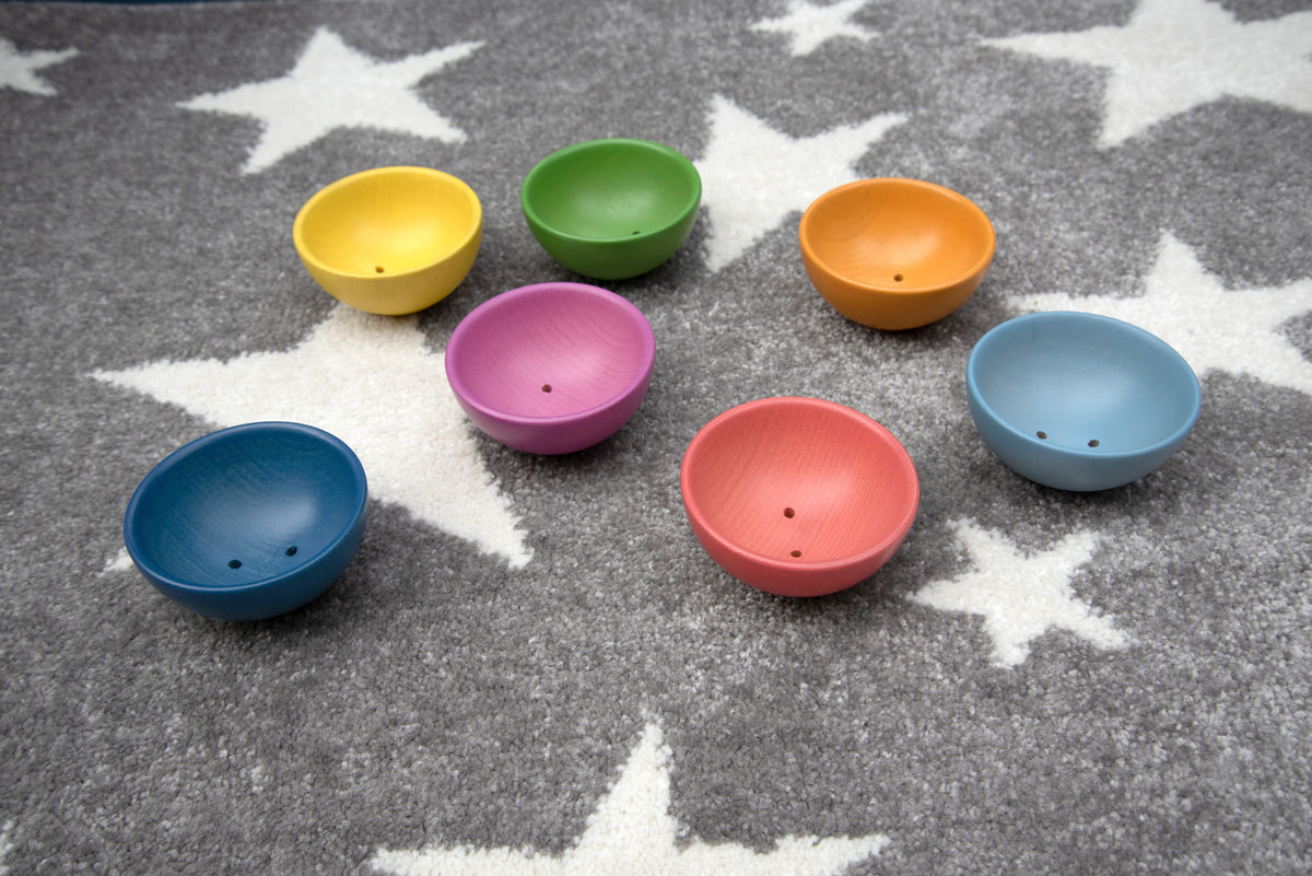 Assorted colorful small bowls in blue, green, pink, orange, and yellow