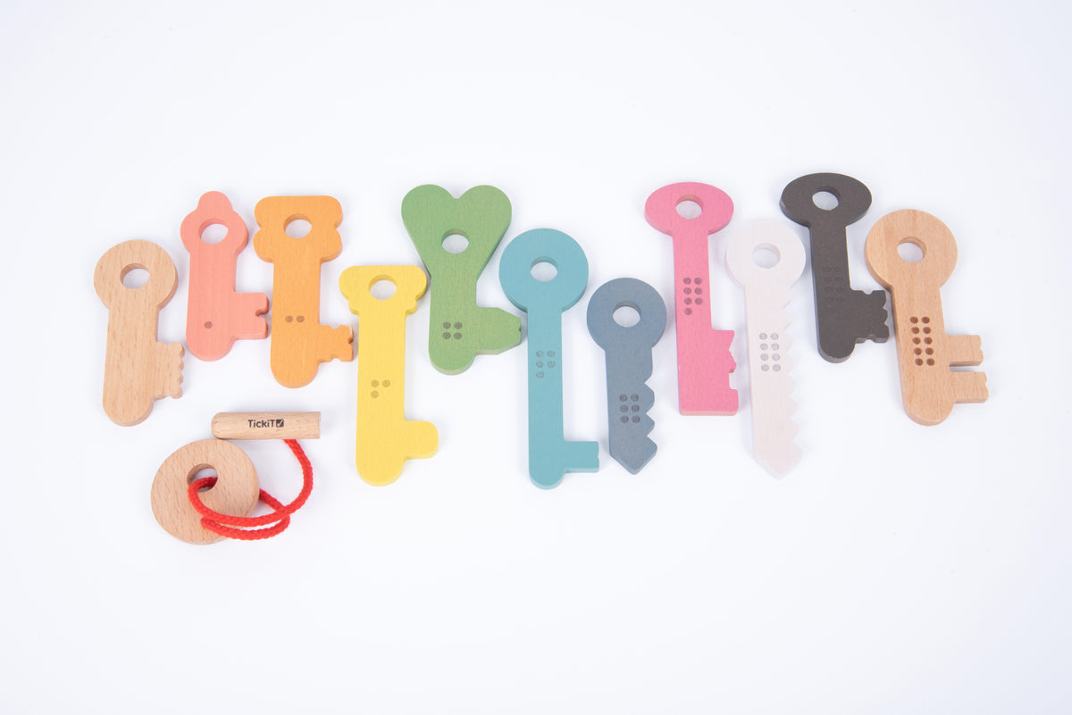 Assorted rainbow wooden counting keys with numbered teeth and a red string loop.