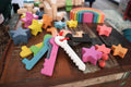 Rainbow wooden counting keys and star-shaped pieces on a tabletop with a red string loop.