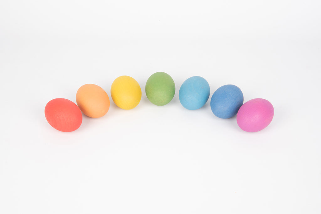 Row of multicolor wooden eggs: orange, yellow, green, blue, pink, purple