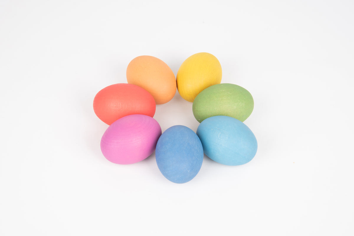 Assorted multicolor wooden eggs grouped together in pastel rainbow colors