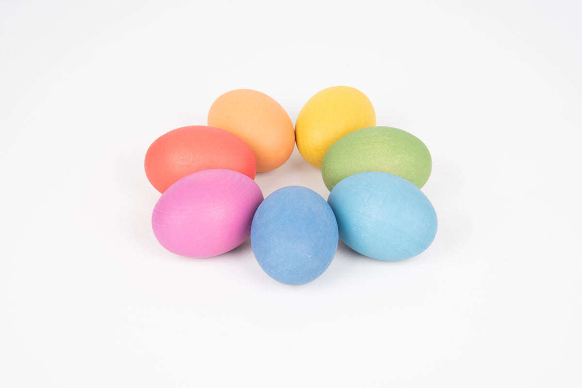 Stack of multicolor wooden eggs in pastel tones: yellow, green, blue, pink, red
