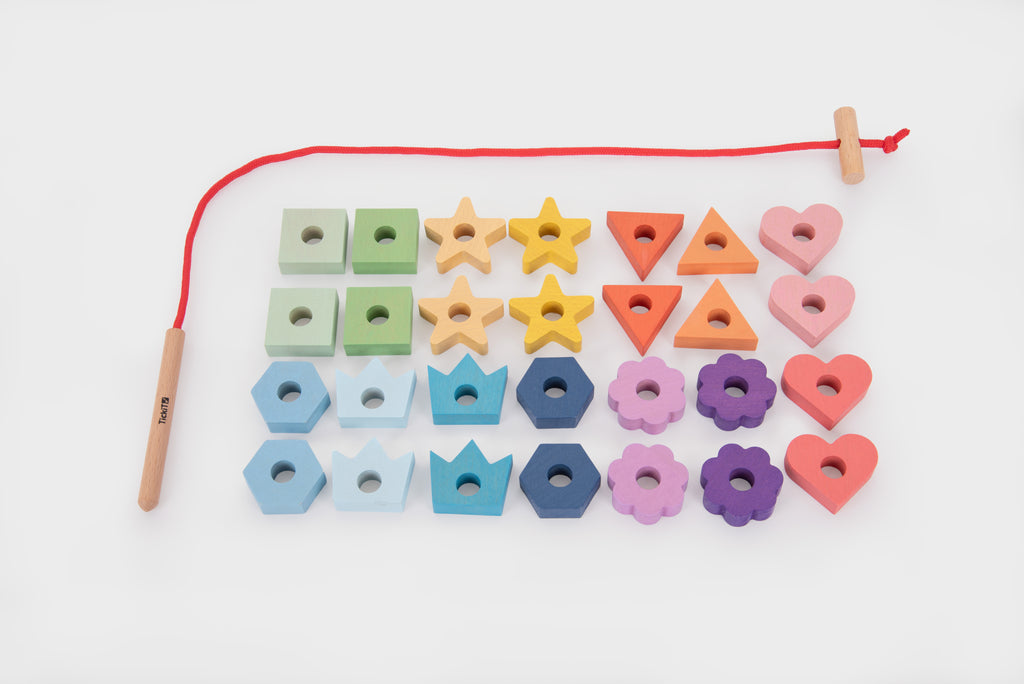 Rainbow wooden lacing shapes flat lay of cube, star, triangle, and heart pieces