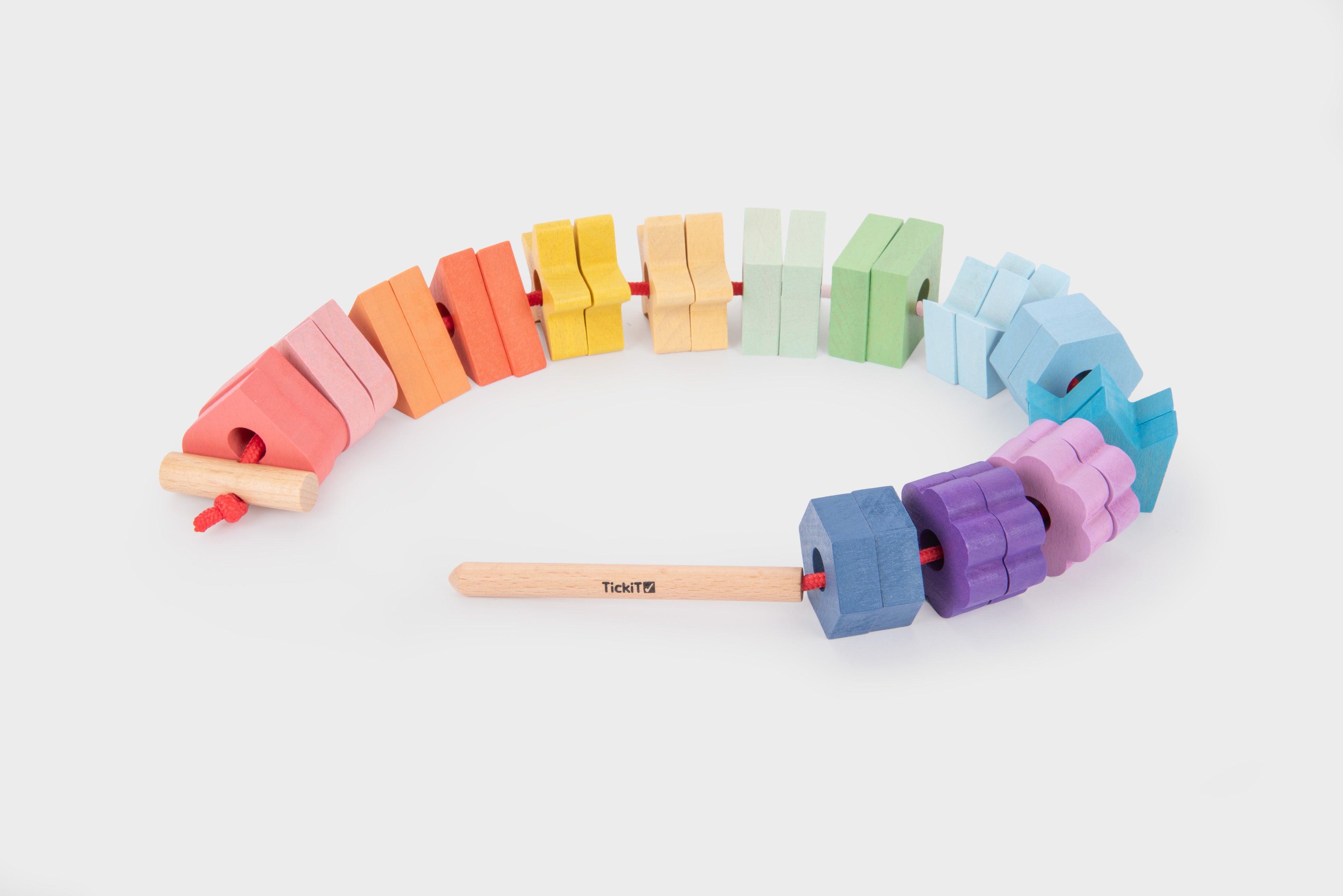 Rainbow wooden lacing shapes set with assorted colored blocks on a red cord