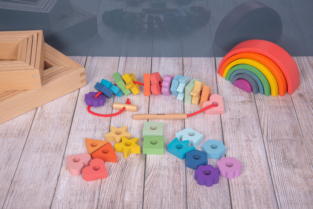 Rainbow wooden lacing shapes with wooden rainbow arch and scattered colored pieces