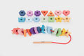 Rainbow wooden lacing shapes with assorted colorful shapes and a red lacing cord