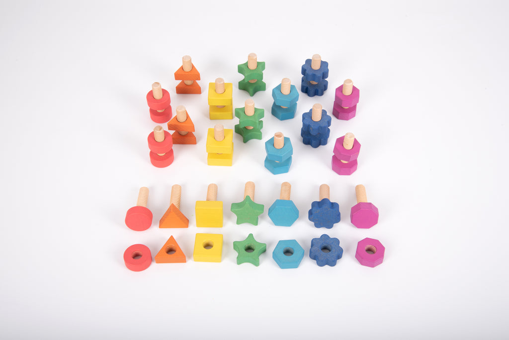 Rainbow wooden nut-and-bolt building pieces laid out in rows, multicolor shapes