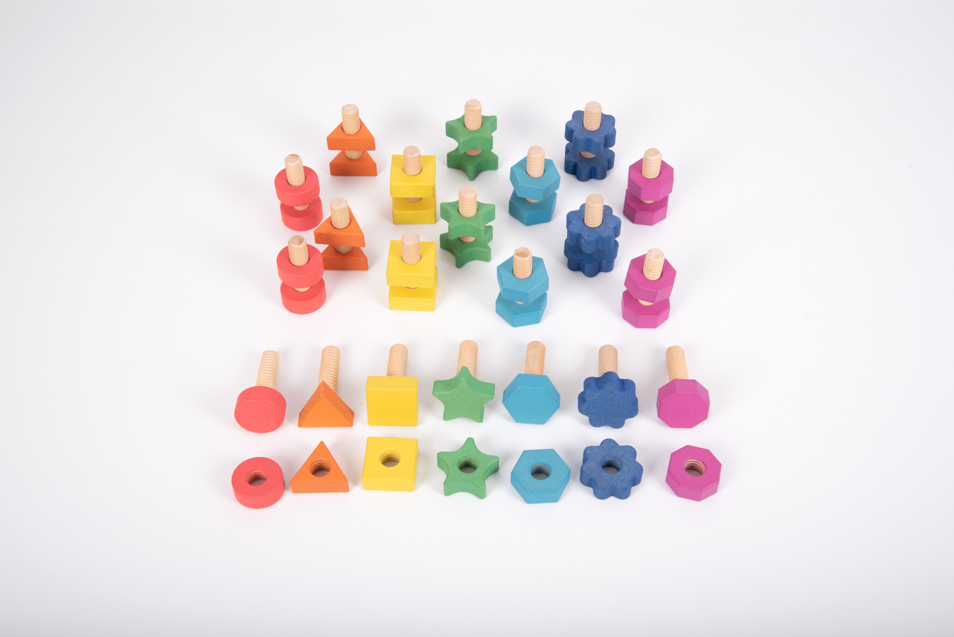 Rainbow wooden nut-and-bolt building pieces laid out in rows, multicolor shapes