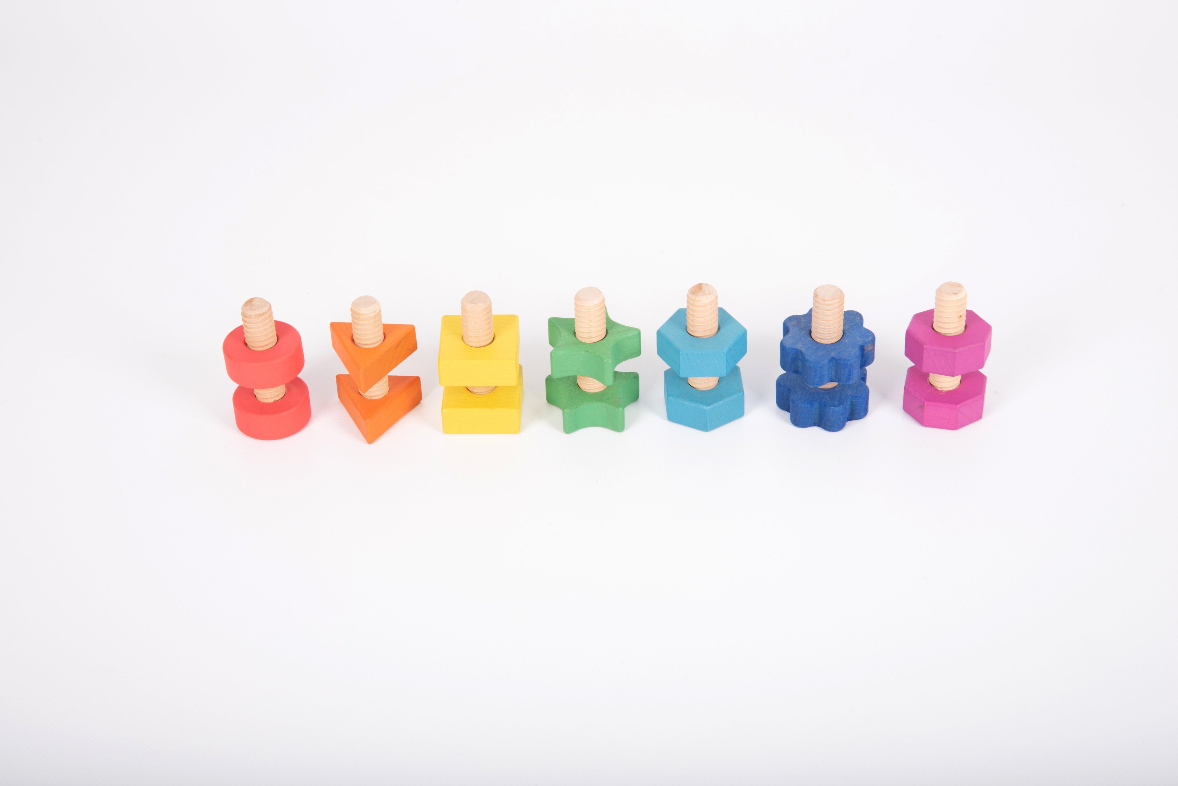 Rainbow wooden nuts and bolts on white: colorful threaded pieces grouped in a line.