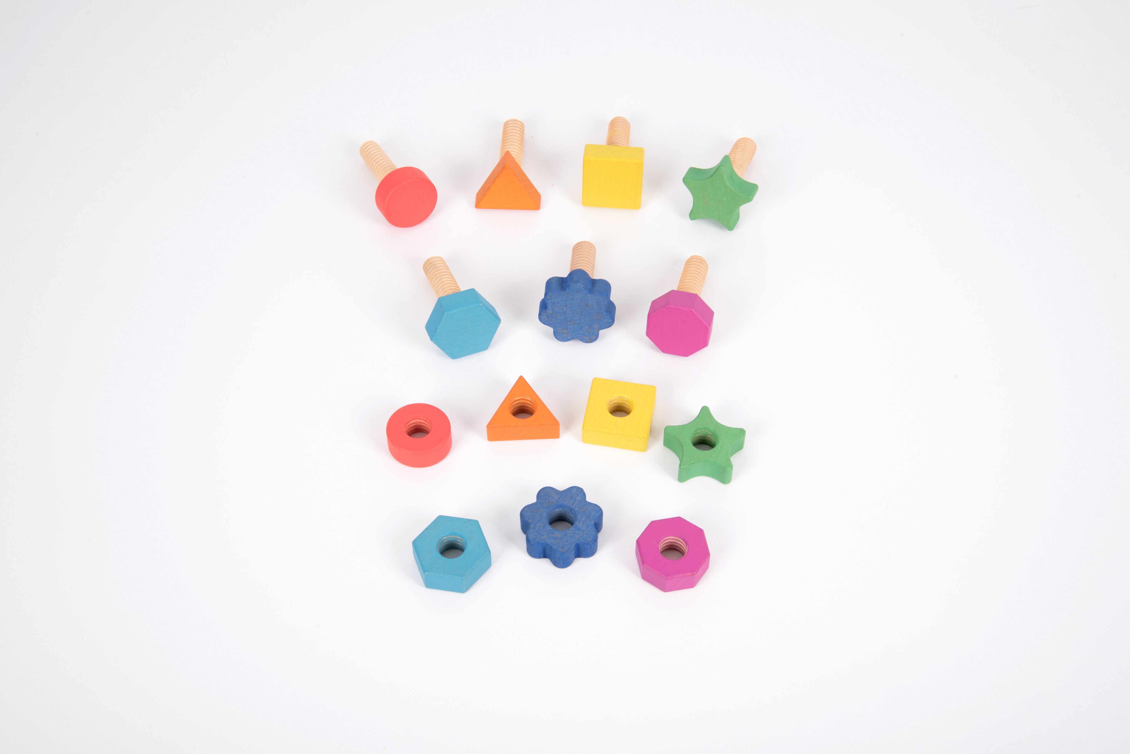 Rainbow wooden nuts and bolts on white: mixed colored nuts and bolts in assorted shapes.