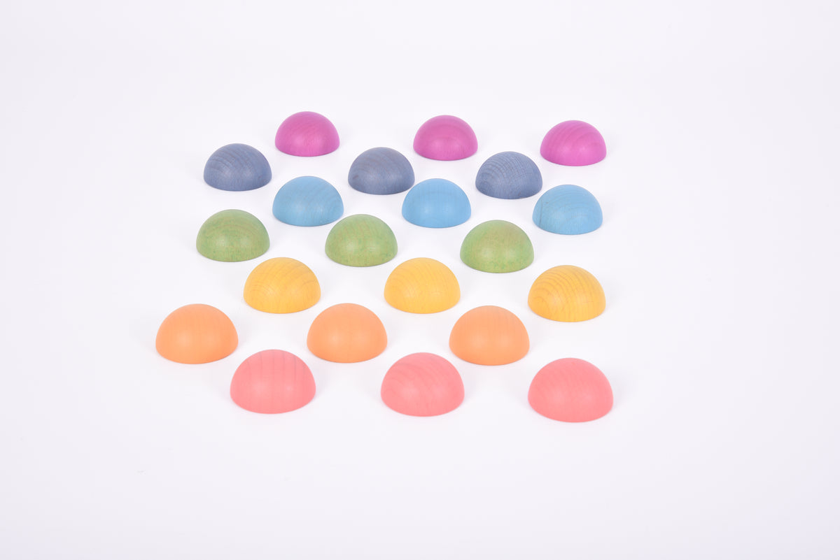 Assorted rainbow wooden semispheres scattered in mixed colors
