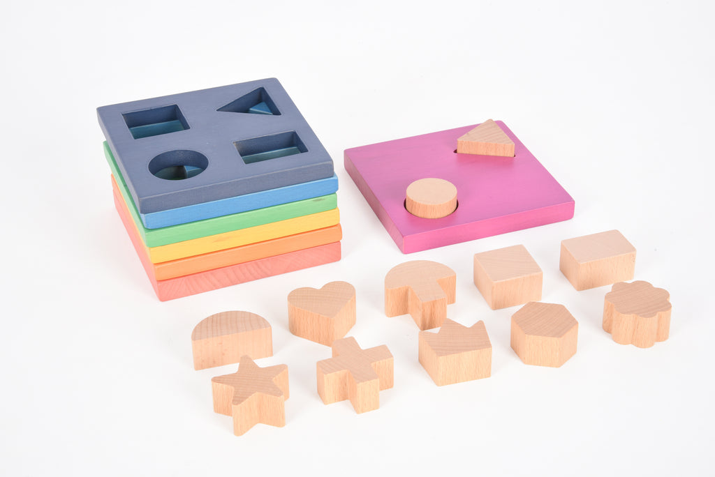 Rainbow wooden shape stacker with heart and round cutout pieces on rainbow layers