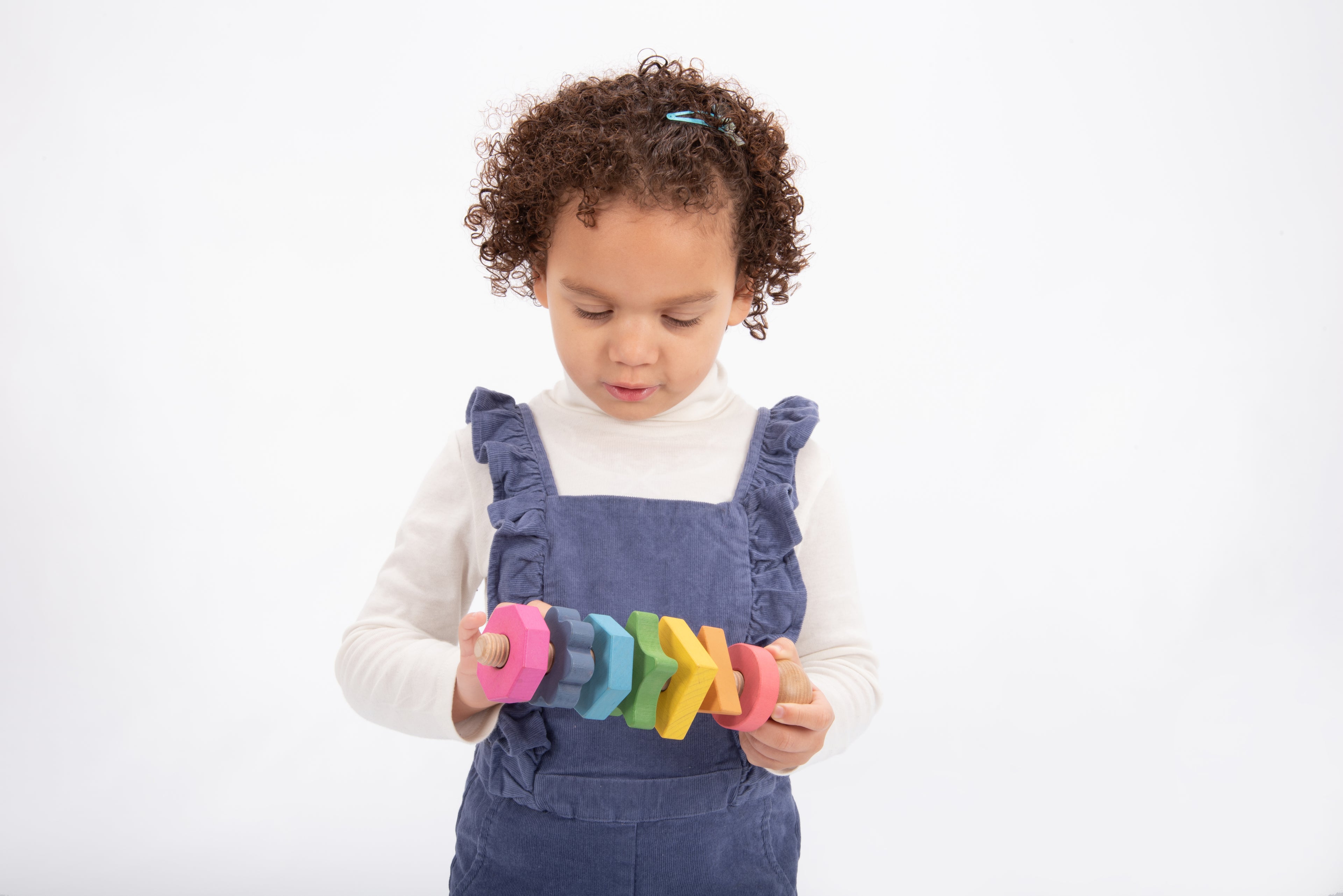 Rainbow wooden shape twister with colorful wooden blocks and stacked rings in hands