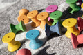 Rainbow wooden thread spools close-up on fabric, yellow, green, blue, pink, and red