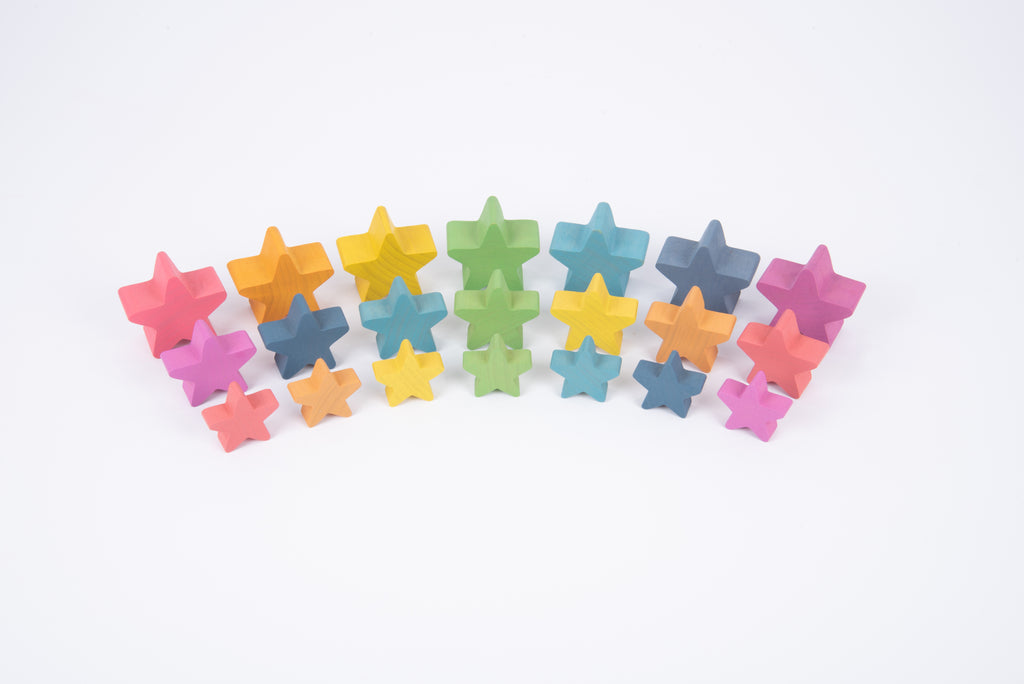 Rainbow wooden star blocks arranged in a single line pile