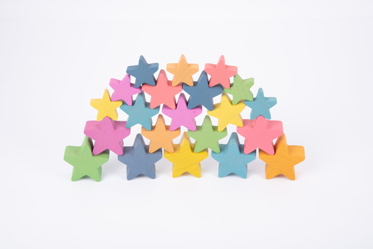 Assorted multicolor wooden star pieces mixed in a pile