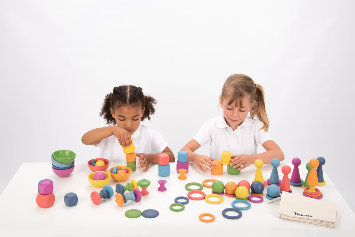 Wooden rainbow stacking toy set with multicolor pegs, rings and ball pieces on table