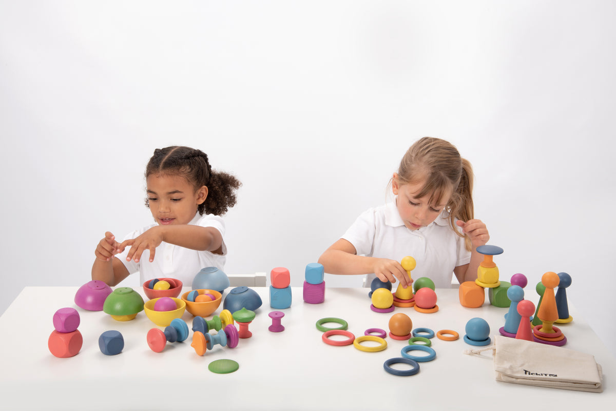 Wooden rainbow toy set with pegs, rings and colorful balls and cones arranged on tabletop