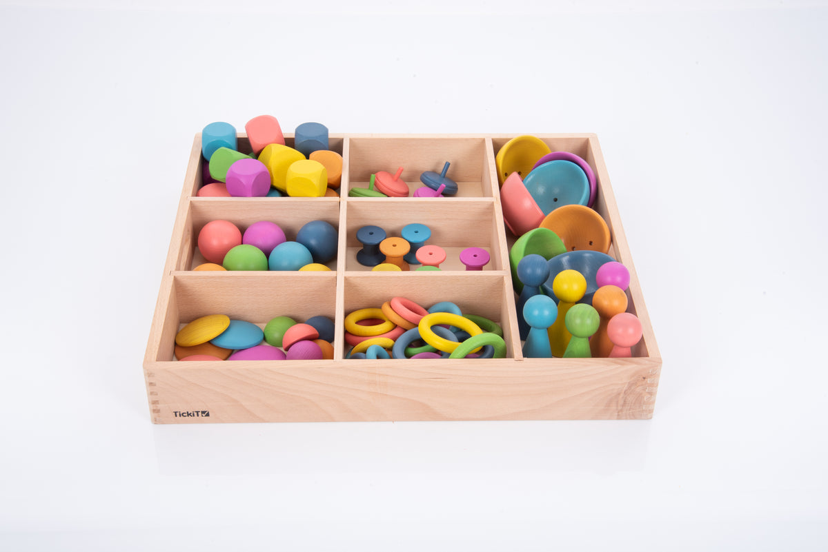 Wooden sorting tray with rainbow pieces in separated compartments, top-down view