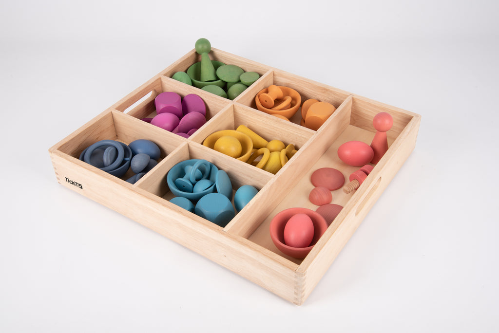 Wooden sorting tray with multicolor rings and discs in divided sections, angled view