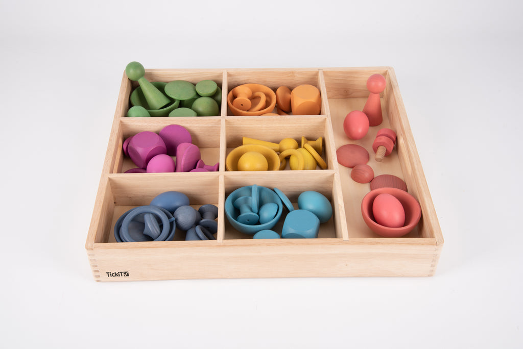 Wooden sorting tray with multicolor stacking rings and discs in compartments, front view