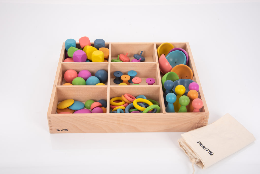 Wooden sorting tray with rainbow rings and cups, with TickTots cloth bag beside it