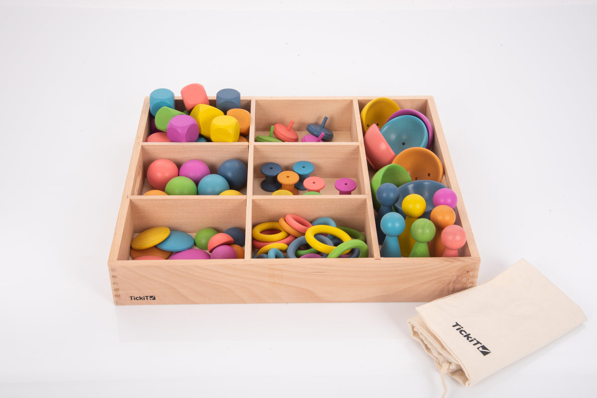 Wooden sorting tray with rainbow rings and cups, with TickTots cloth bag beside it