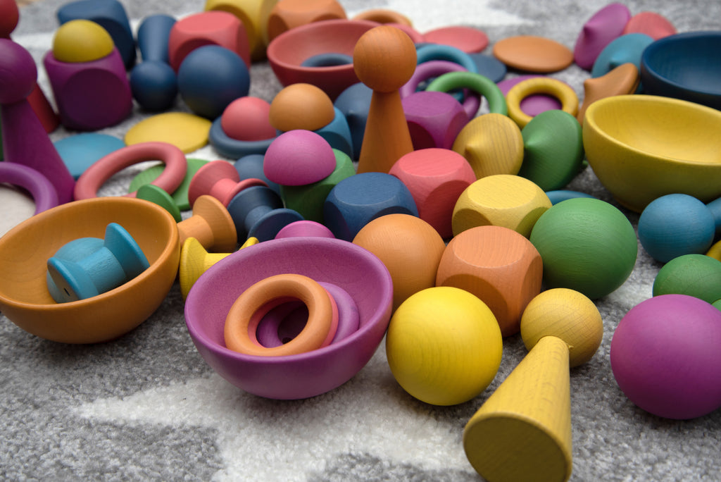 Close-up of colorful wooden pegs, bowls and stacking pieces in assorted rainbow colors
