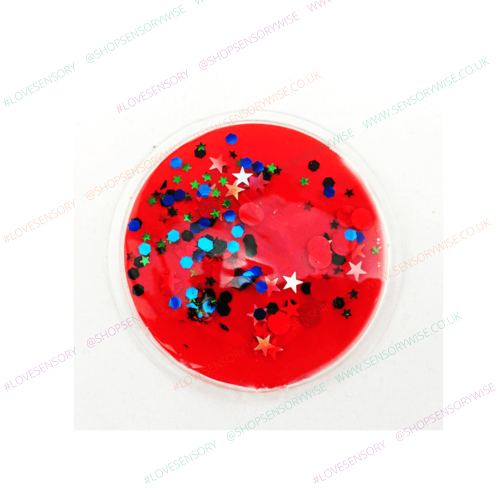 Sensory glitter disc with domed clear top, bright red base with blue stars and green accents