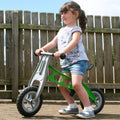 Green mini cruiser balance bike with white frame and black handlebars, small kids size