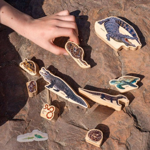 Reptile-shaped wooden cutout pieces with colorful animal illustrations