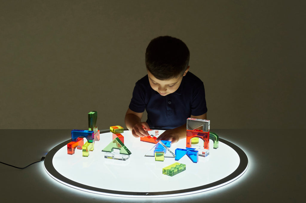 Round LED light panel glowing on tabletop, cable attached to outer edge