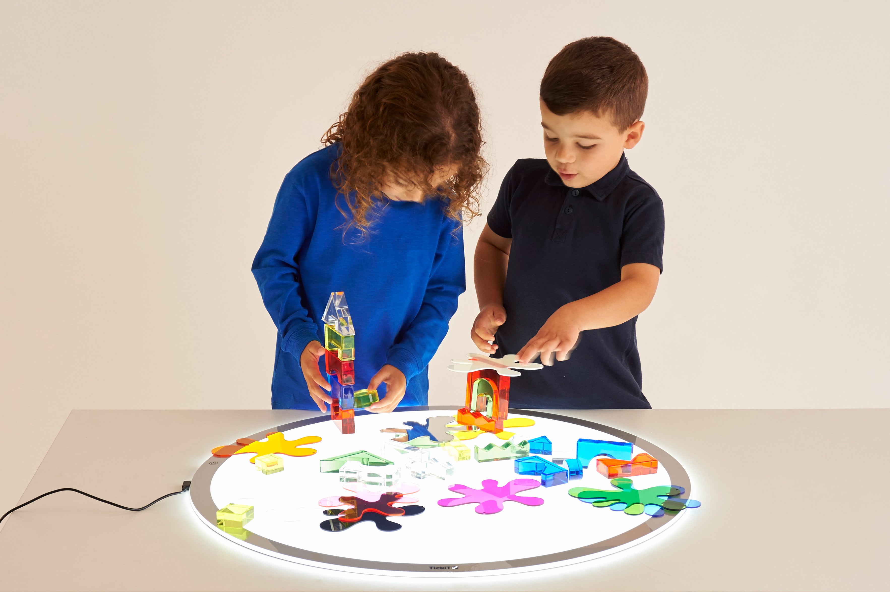 Round LED light panel on floor with glowing rim and white working surface
