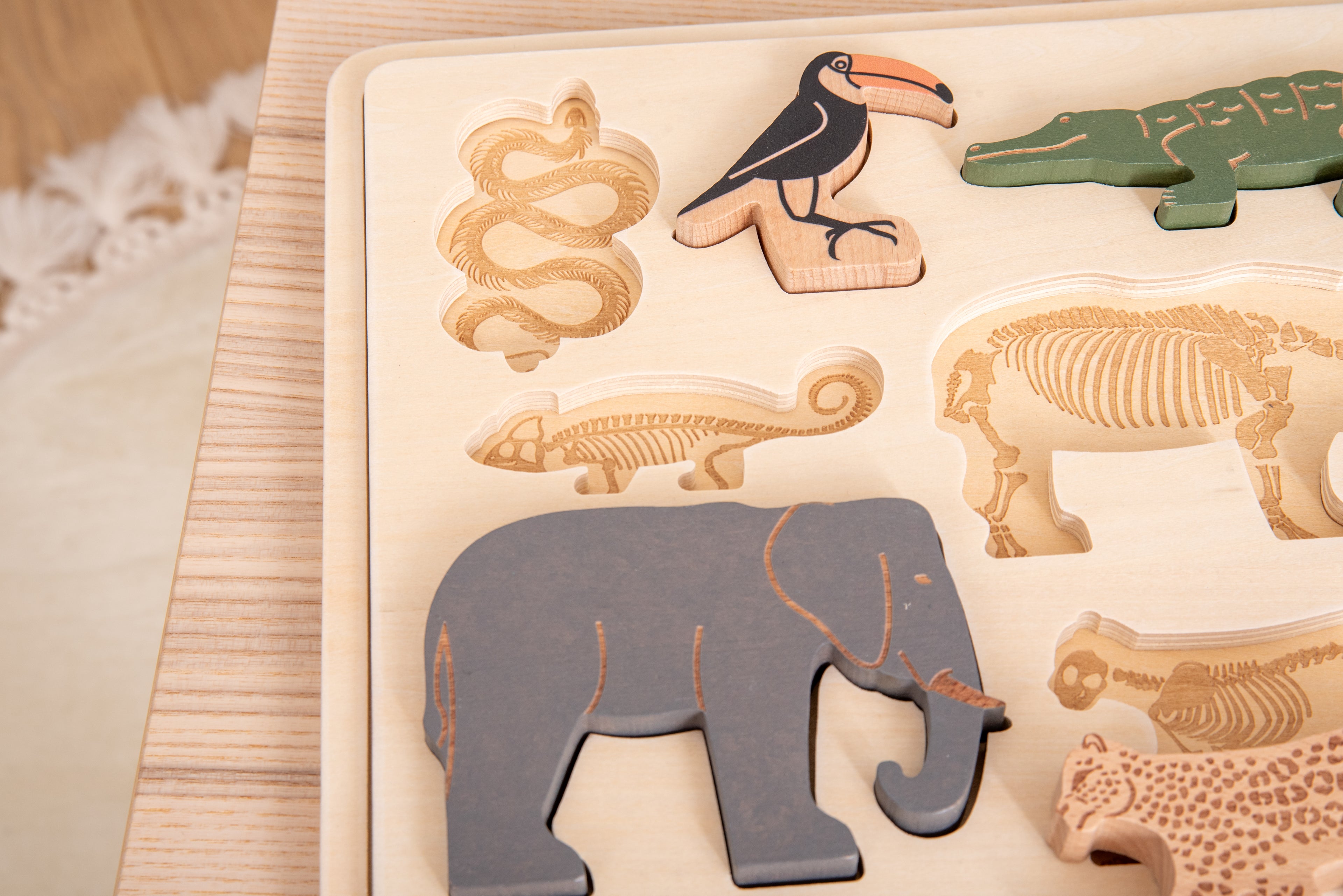 Close-up of layered safari animal puzzle board with elephant and zebra pieces