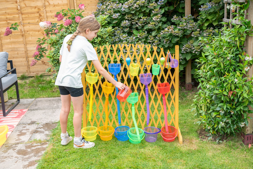 Yellow water play gate with colorful hanging cups; child playing