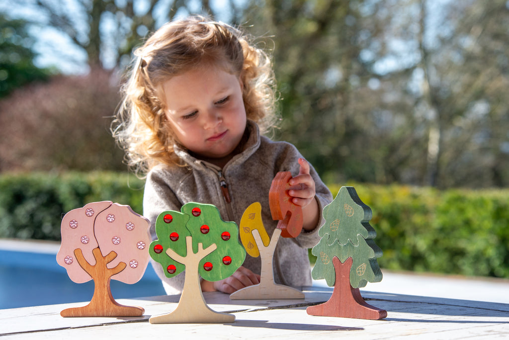 Wooden gem tree pieces with red, green, and orange details for kids to play
