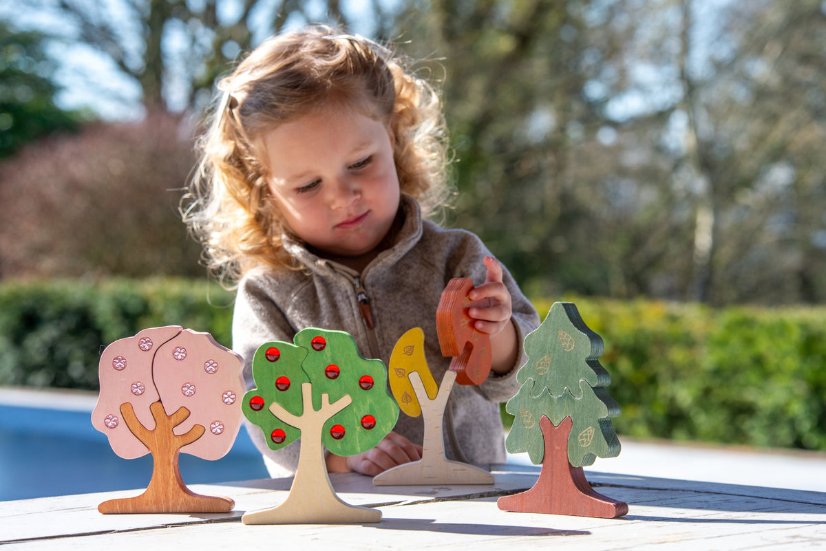 Wooden gem tree pieces with red, green, and orange details for kids to play
