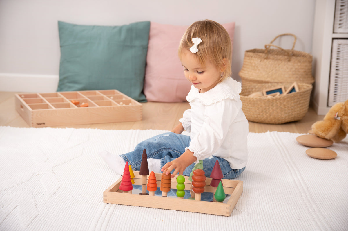 Multicolor wooden tree figures and tray on play surface