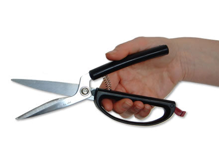 Kitchen shears with self-opening handle, held in hand; black grip, stainless blades