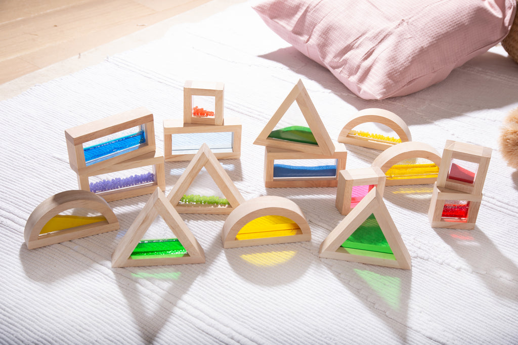 Wooden sensory blocks with colorful bead panels arranged on fabric