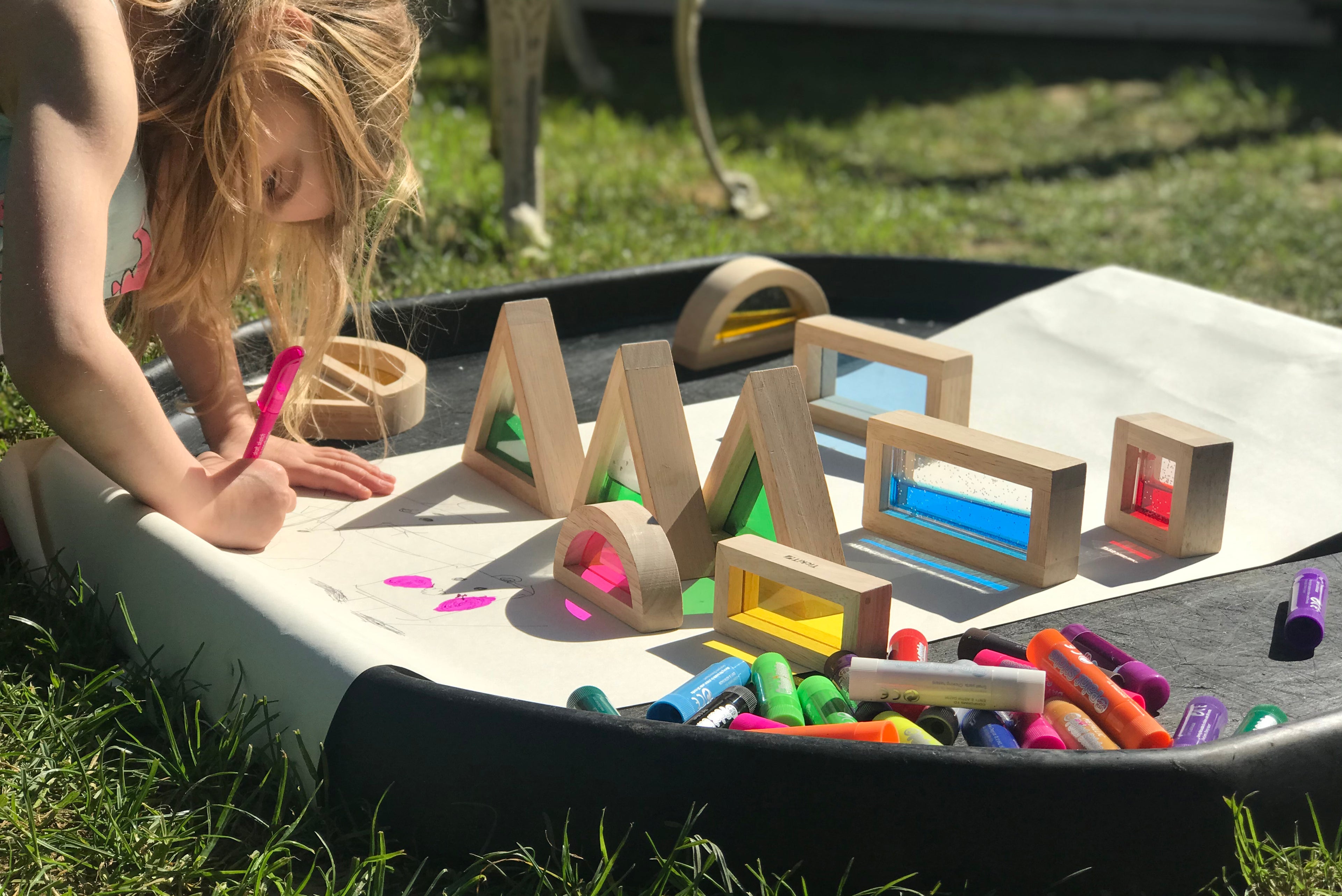Wooden sensory blocks on outdoor play mat with colored bead inserts