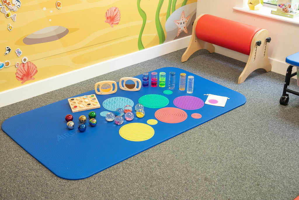 Floor sensory activity mat with colorful textured circles, jars, and bead balls