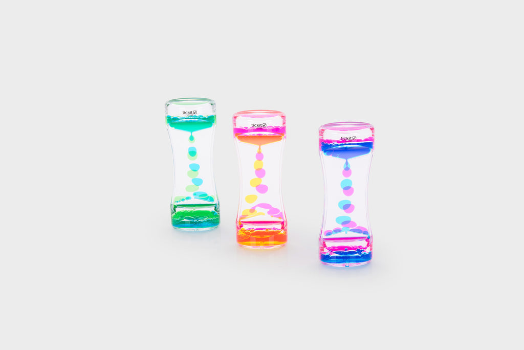 Three translucent rainbow sand timers at angles, with green, pink, and blue bead cascades