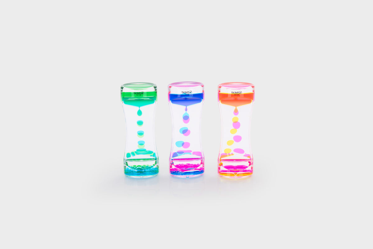 Three translucent rainbow sand timers with colored bead cascades: green, pink, blue