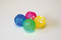 Set of four translucent flashing sensory balls in blue, pink, green, and yellow