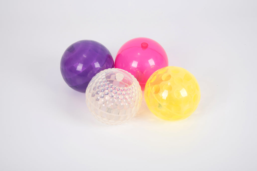Set of four textured flashing balls in purple, pink, clear, and yellow